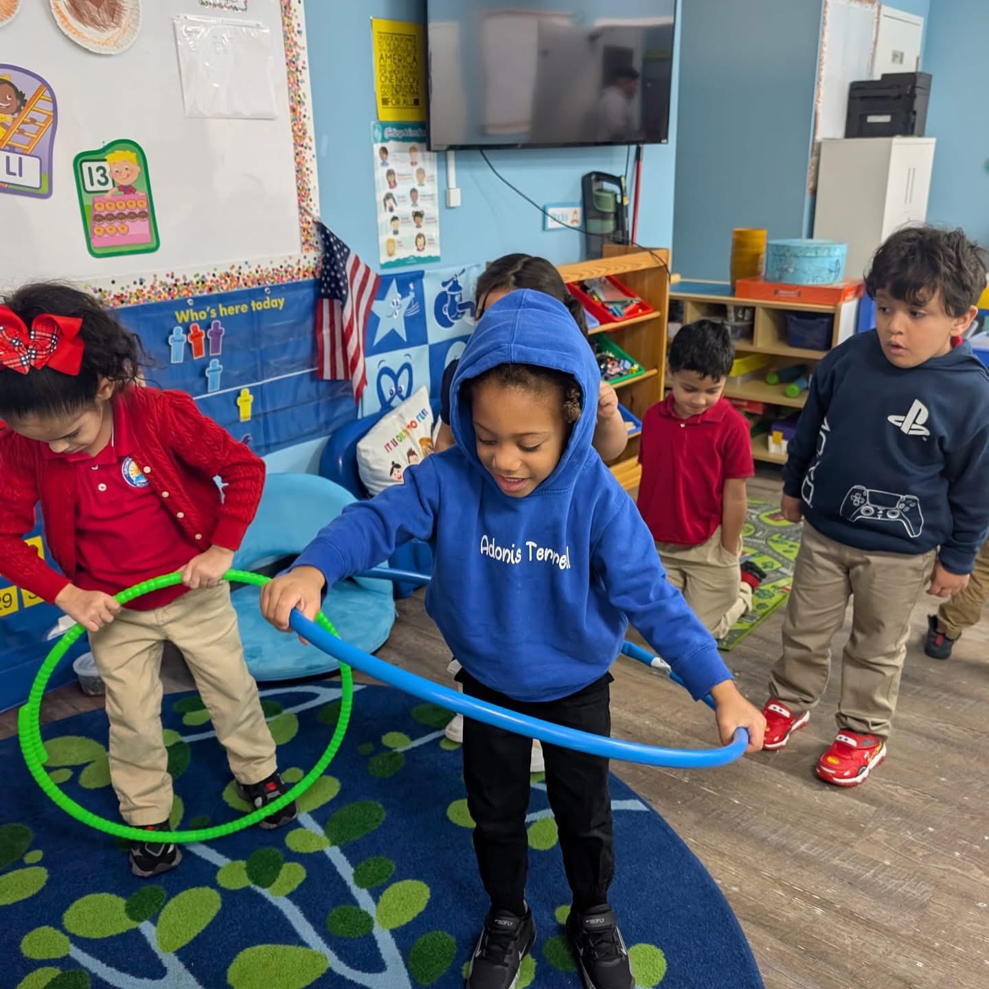Children playing with hula hoops indoors during movement activities at Growing Together Academy